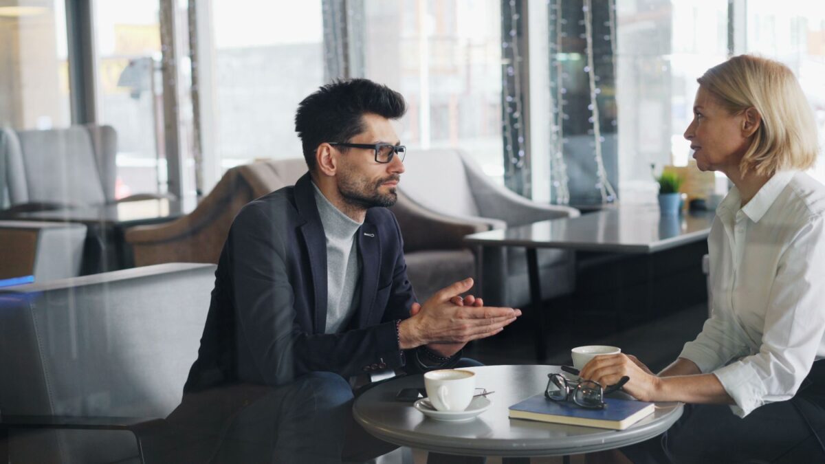 Professional conversant amb un client durant una reunió comercial