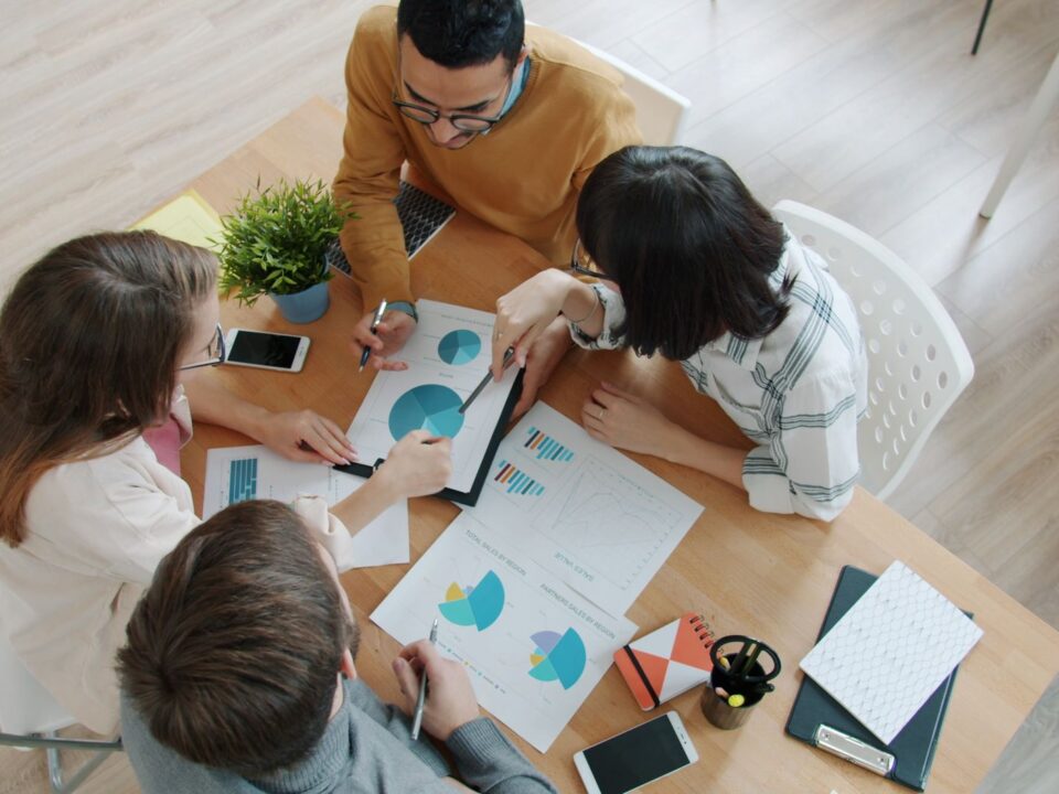 Equip comercial revisant informació de clients en una oficina